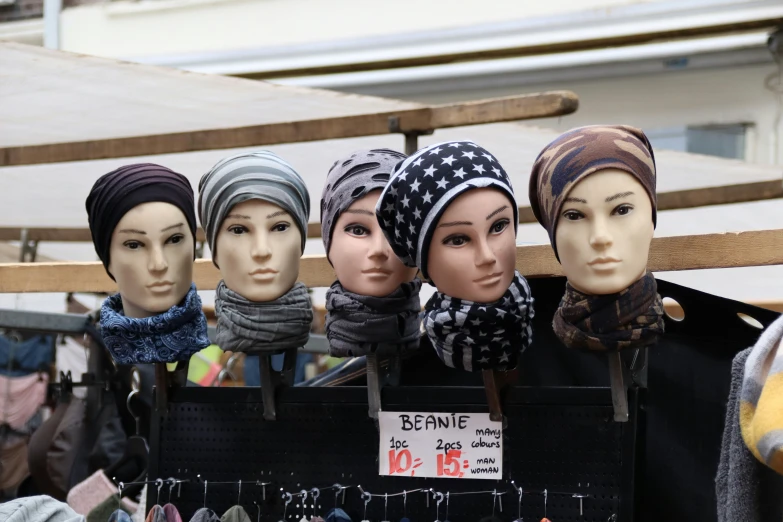 a display case with multiple head pieces of mannequins wearing headscarves