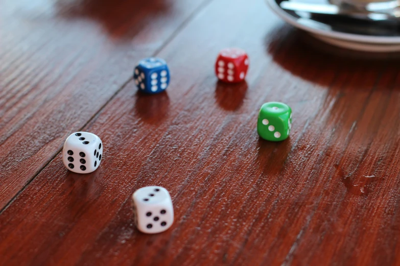 seven dice are sitting on the floor in front of a spoon