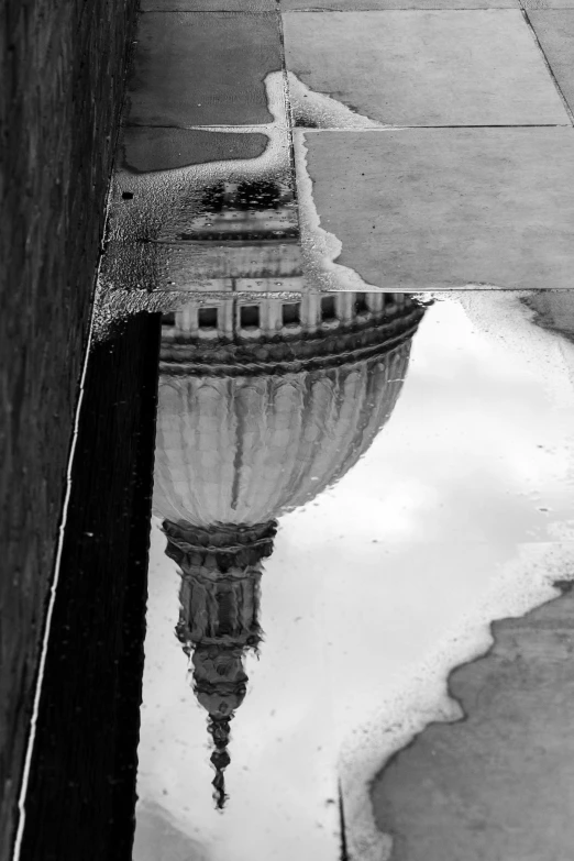 a reflection of a building in water on the street