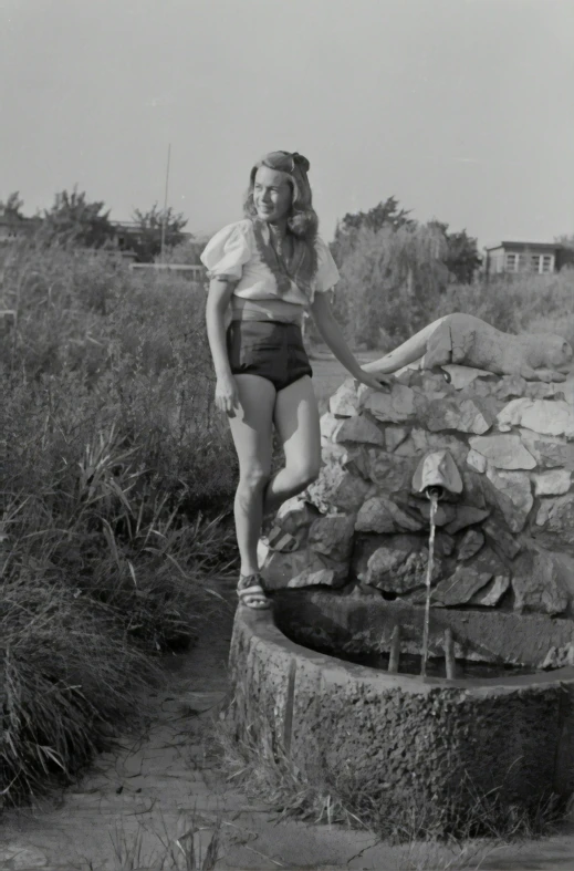 a woman that is standing on some rocks