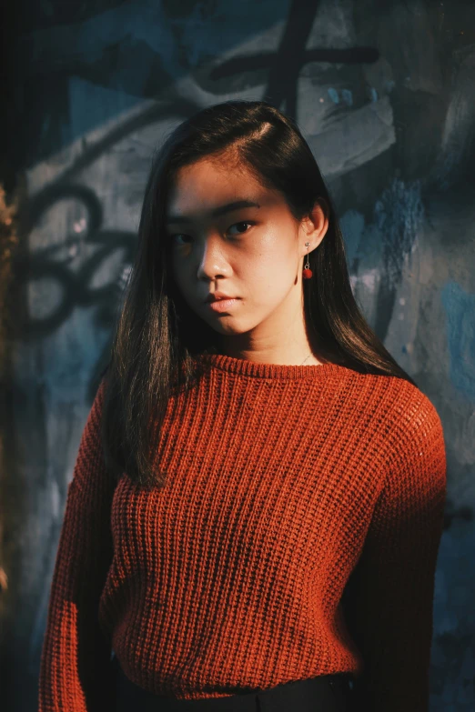 woman in a red sweater poses for a picture