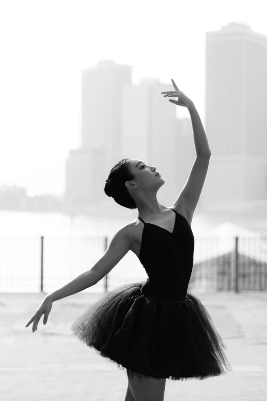 a woman in black and white ballet dress is doing a hand stand