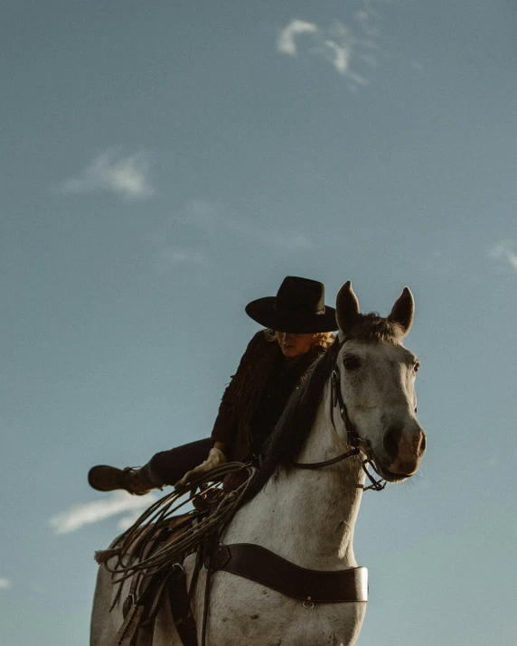 a cowboy riding on the back of a white horse