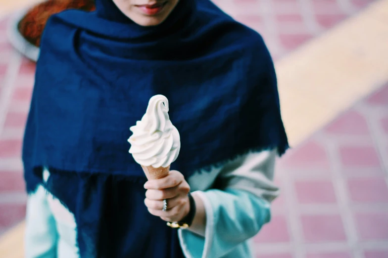 the woman is holding up an ice cream cone