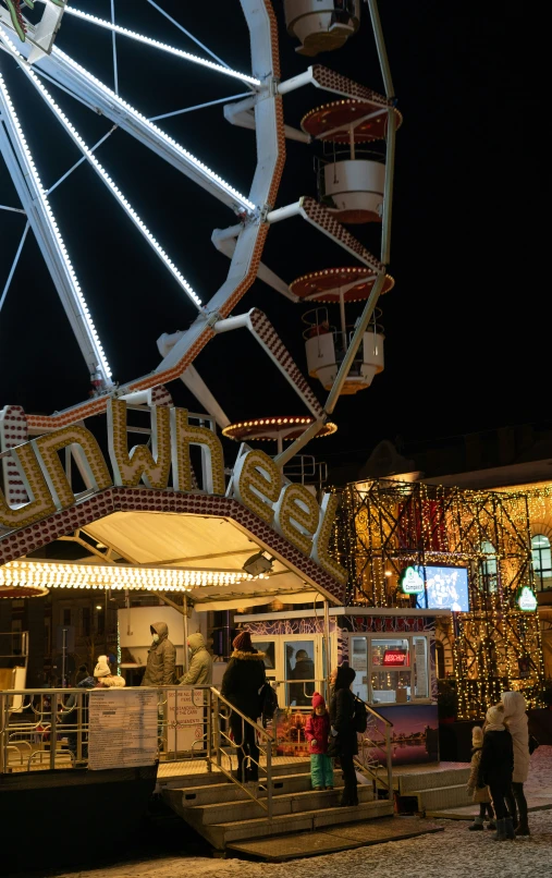 a ferris wheel with people milling around at the fair