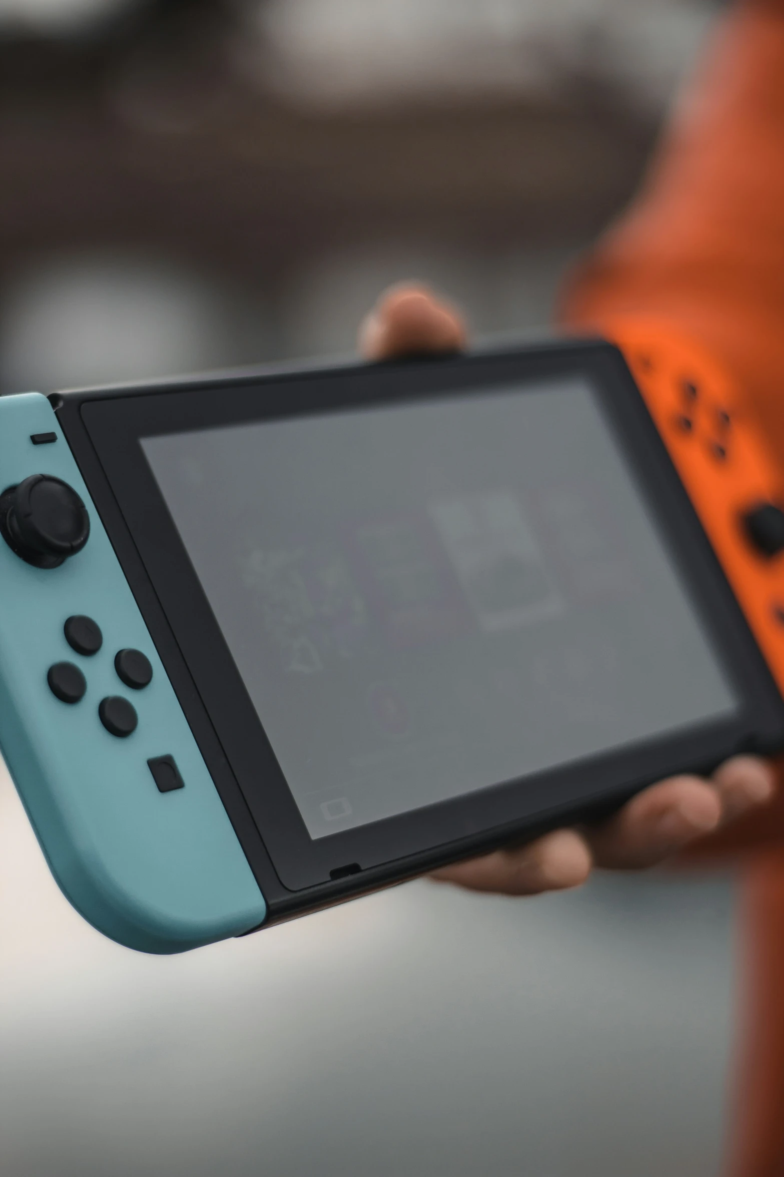 the person is holding a blue nintendo switch game system