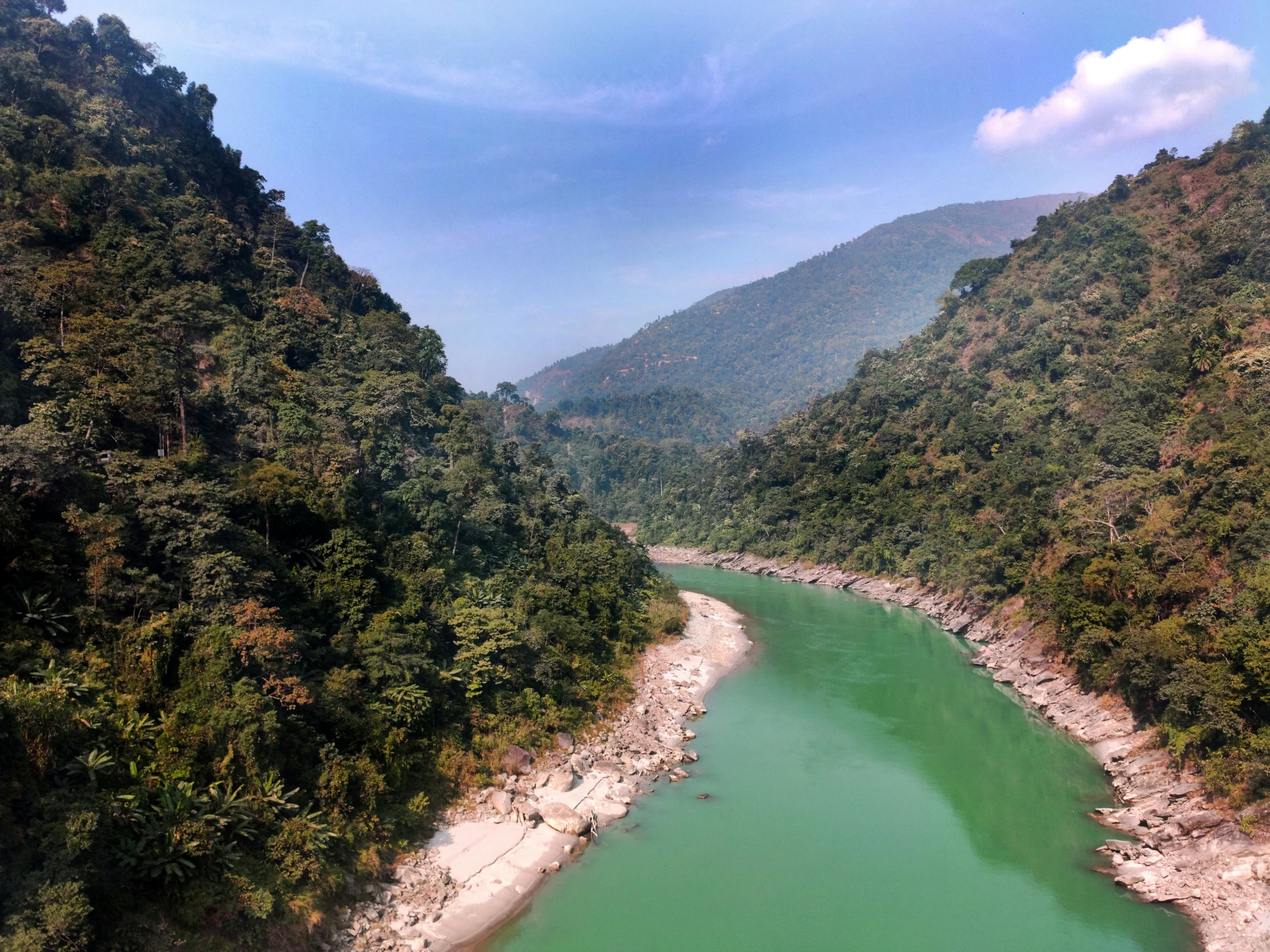 the green river is flowing between two steep mountains