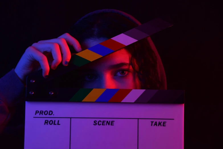 a woman staring at a camera behind a clapperboard