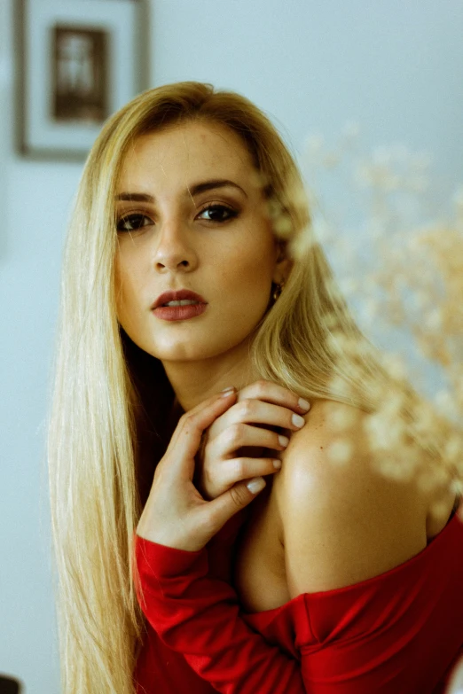 a woman with long blonde hair and big  looks away from the camera