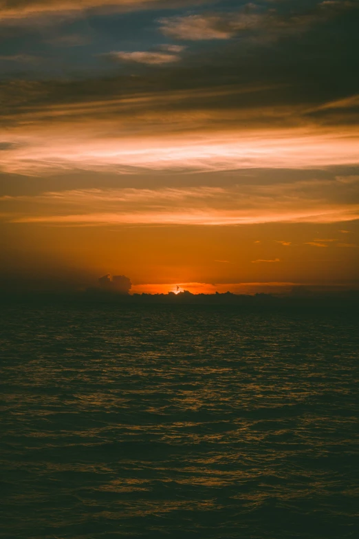 the sun setting on the horizon over the ocean