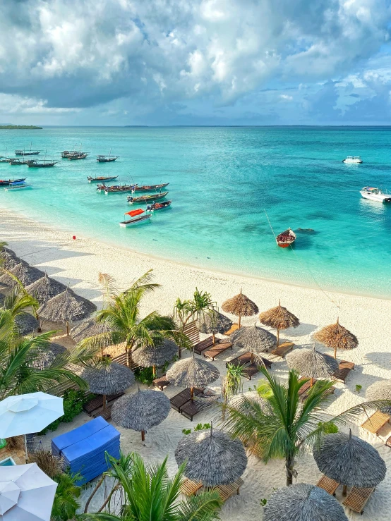 an aerial view of a beach, huts and the ocean