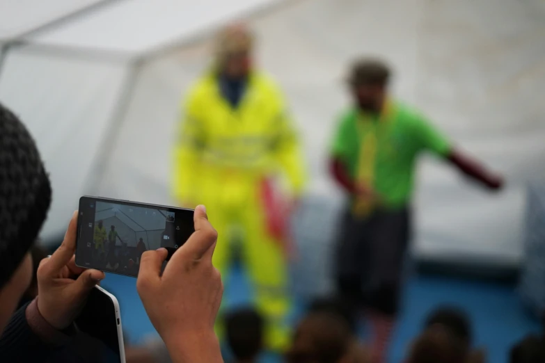 person with a camera and a group of people watching