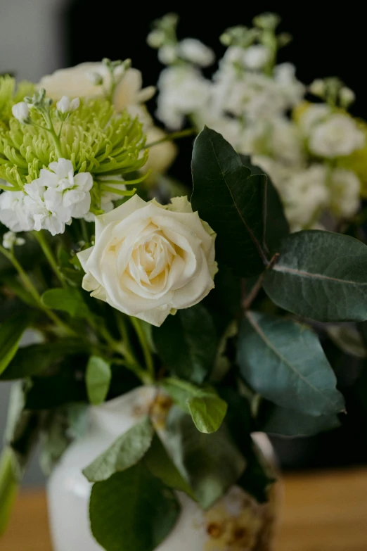 two vases with white and green flowers in them