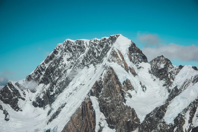 a snowboarder is standing atop a huge mountain