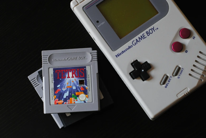 a small grey and black game boy and a gray electronic game