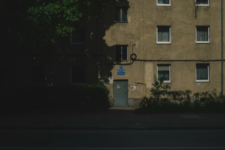 a person walking near an apartment building with vines growing around the windows