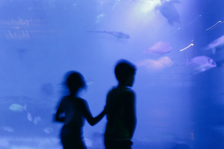 two people walking on a stage in front of a light