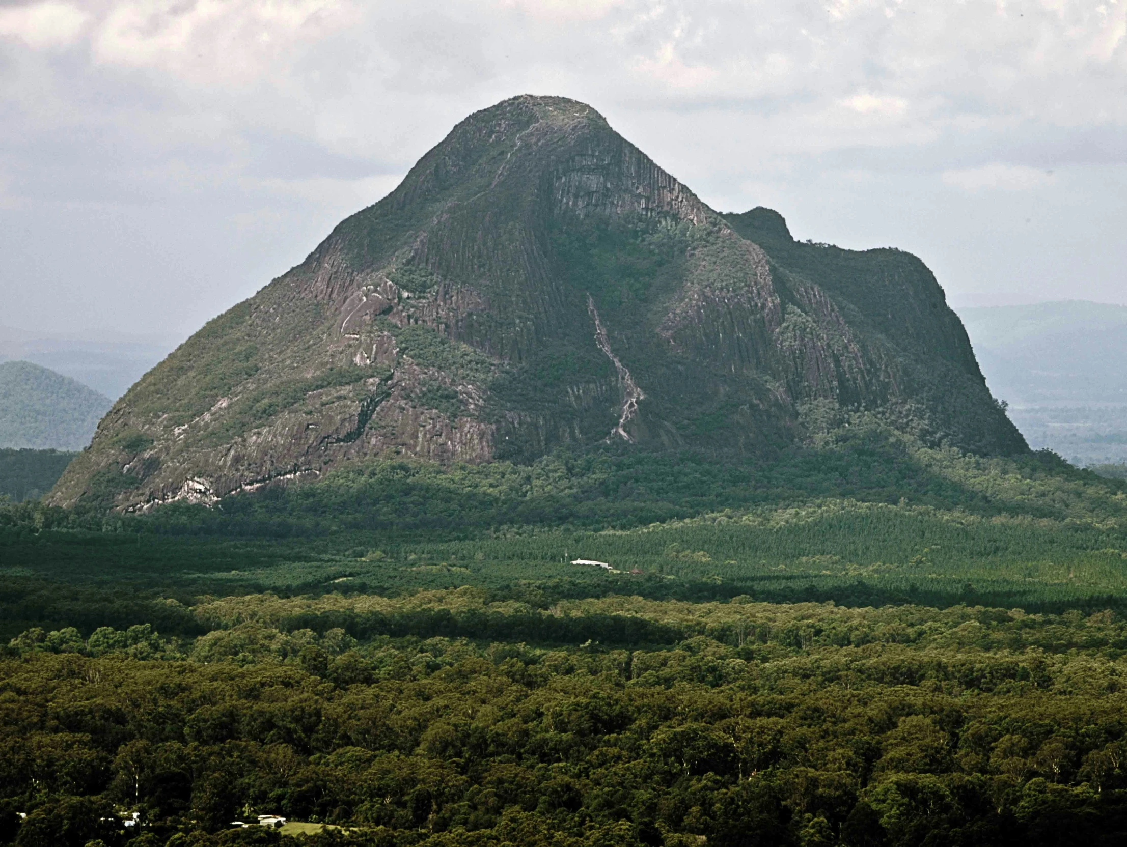 the mountains in the valley are tall with green trees