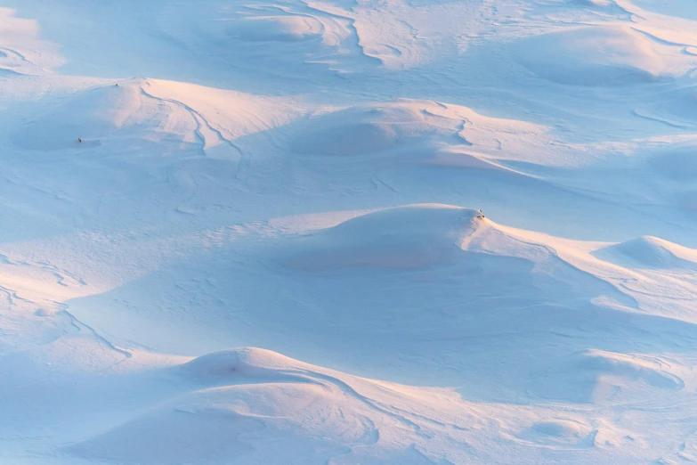 an aerial view of snow covered mountains in the background