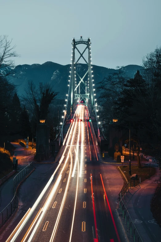 cars drive over a bridge in the evening