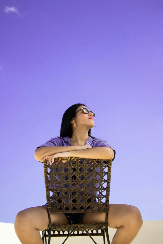 a woman sitting in a chair, facing upwards