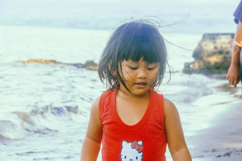 little girl walking along a body of water