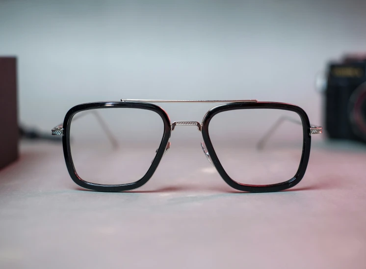 an eyeglasses sits next to an analog camera