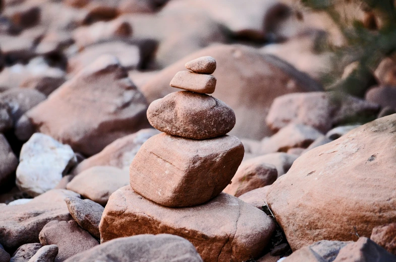 some rocks on the ground with one of them balanced