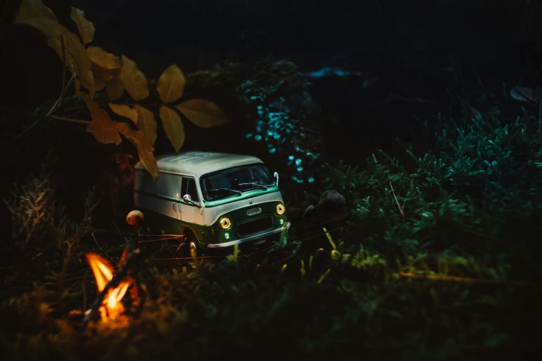 an old truck sits outside at night near some campfires