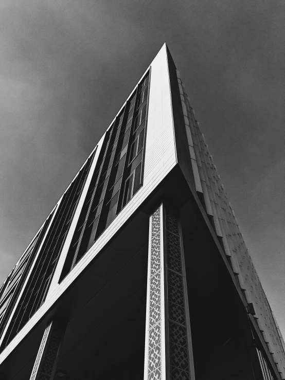 the side of an architectural building with vertical lines and a very tall window