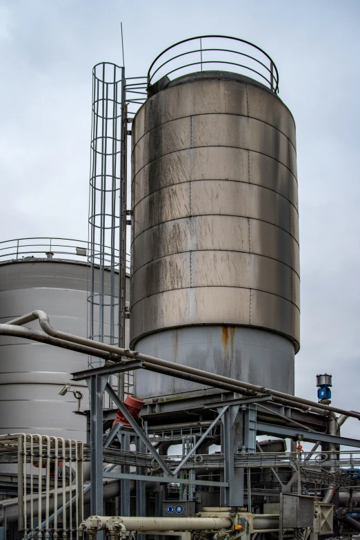 a large metal tank sitting next to an industrial building