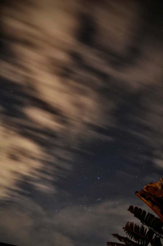 a night sky with clouds and some stars