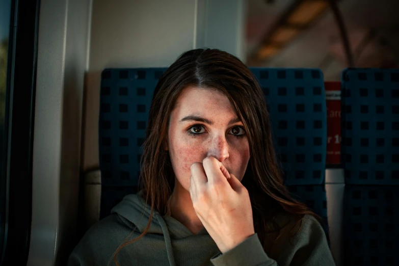 a girl on a train blowing her nose