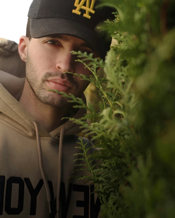 a man wearing a hat that is sitting in the grass