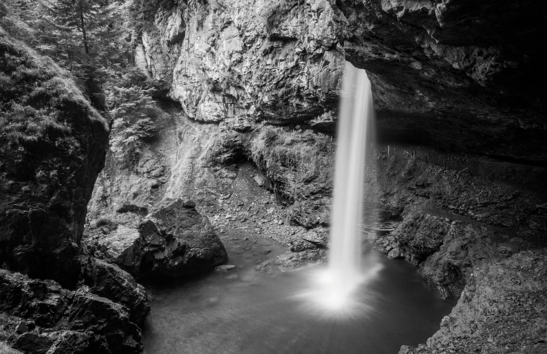 a large waterfall with a small light at the bottom