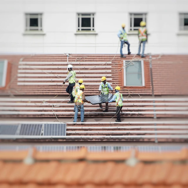 several workers on the side of a building cleaning the bleachers