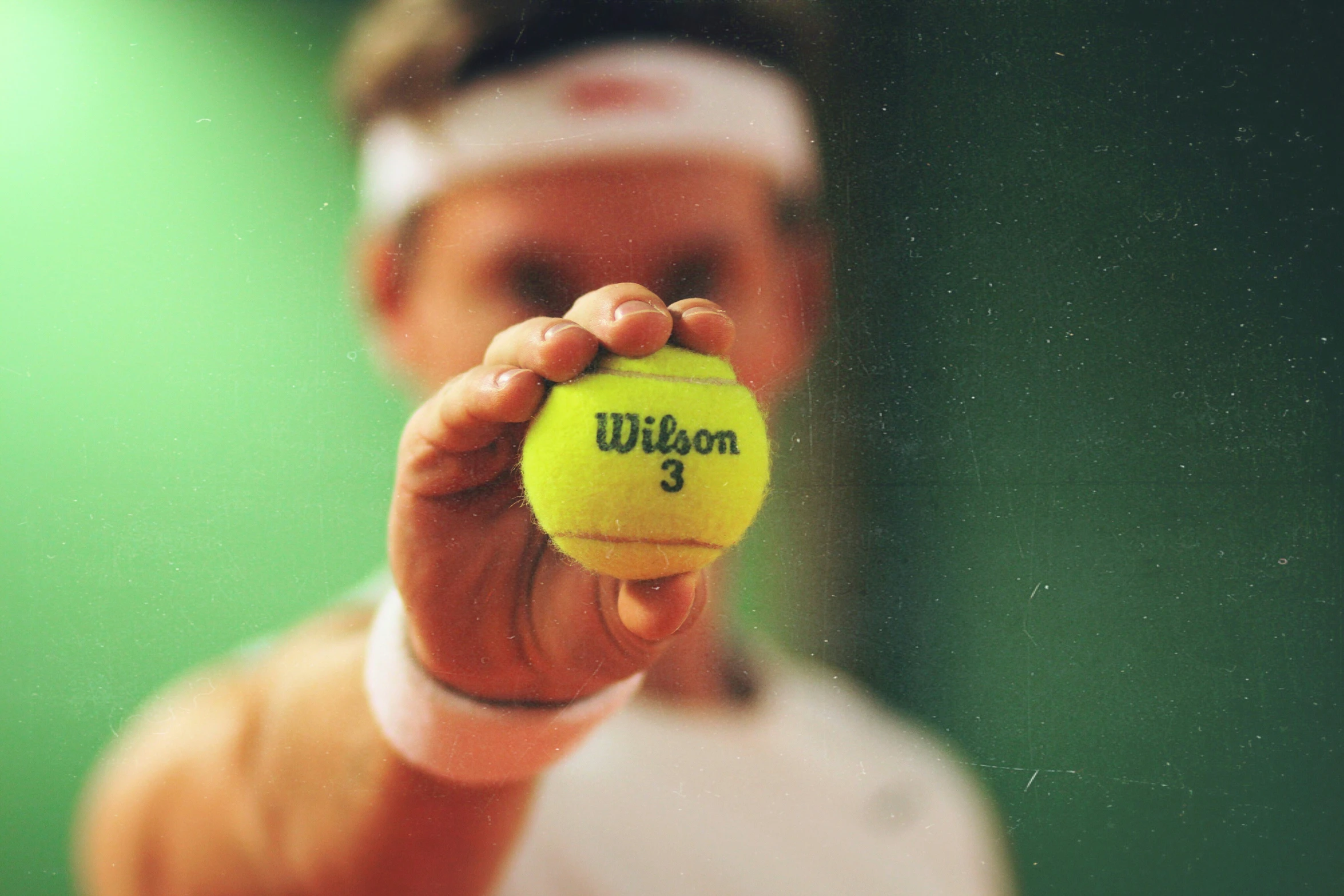 the boy is holding a yellow ball in his hands