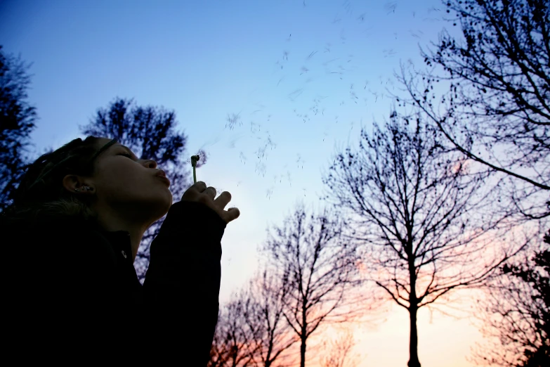 woman smelling soing with trees in the background