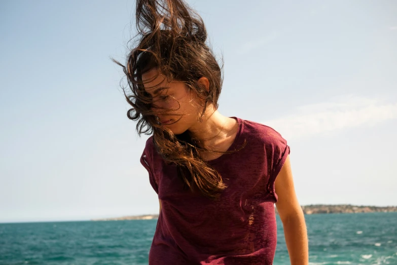 a woman with her hair in the wind on the beach