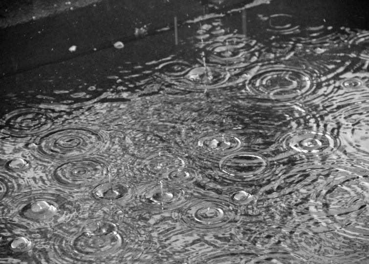 black and white pograph of water that has been formed by raindrops