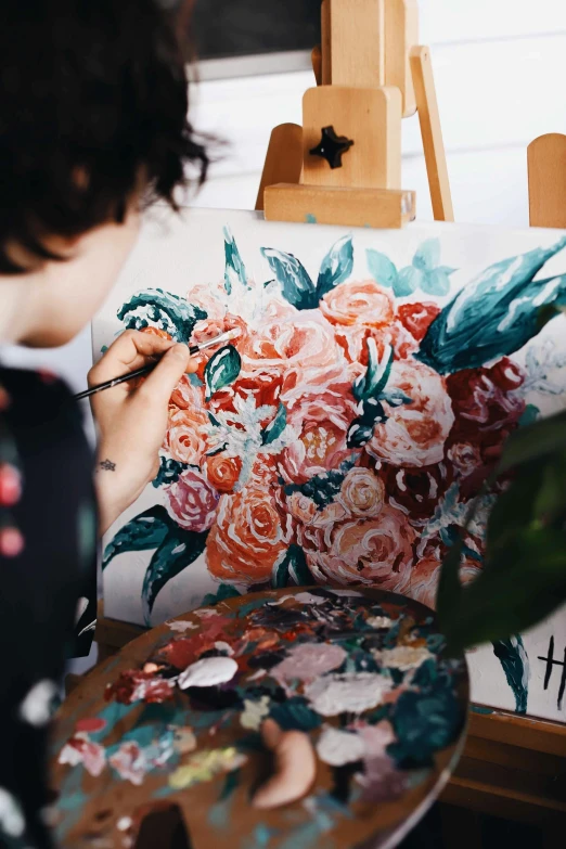 a woman painting flowers in bright, artistic colors