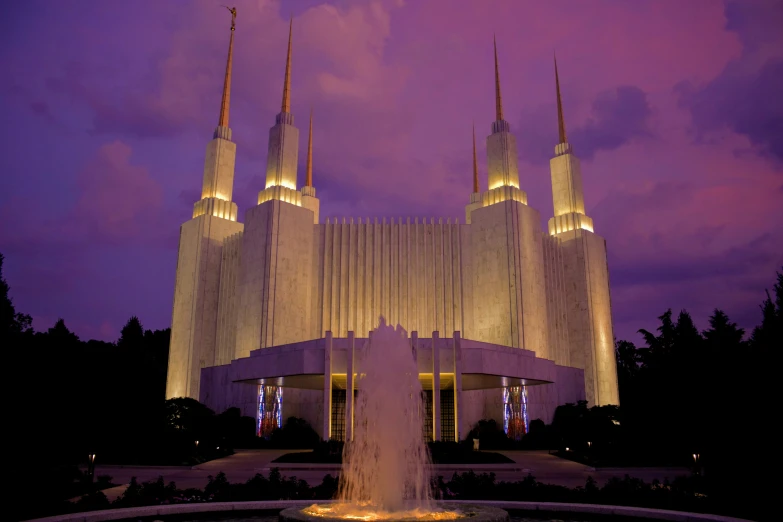 a large white building that has lit up in the evening