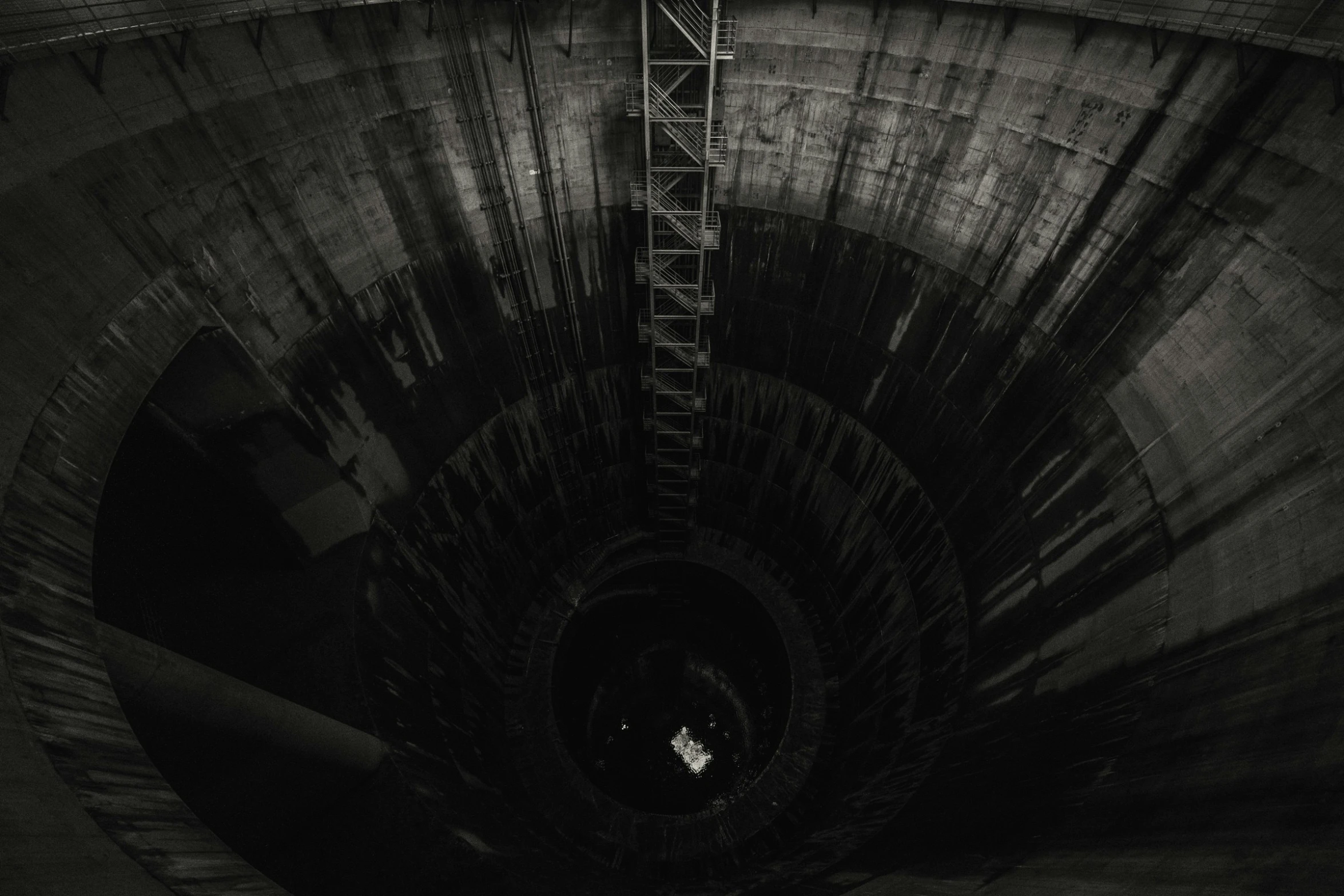 an inside view of a large open tank with a very long ladder