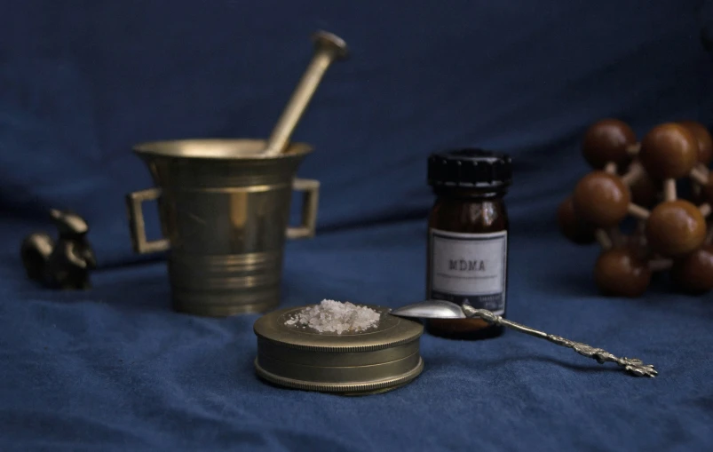 a tea cup and spoon next to a container of powder