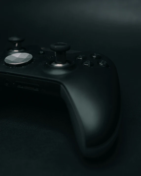 black controller, close up, on table against black background