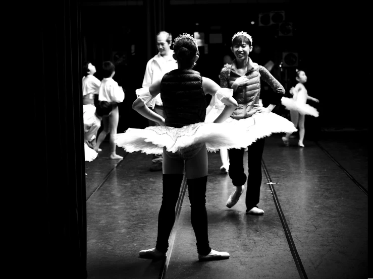 a man in ballet tutu standing near another person holding a ball