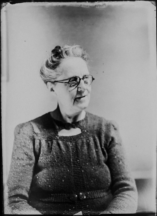 old pograph of an older woman sitting in front of a white background