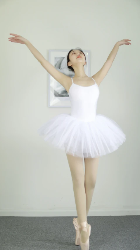 a female ballerina wearing a white ballet outfit is stretching out her arms