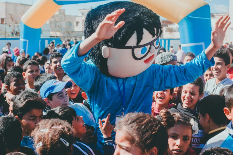 a person with a huge puppet is standing over a crowd