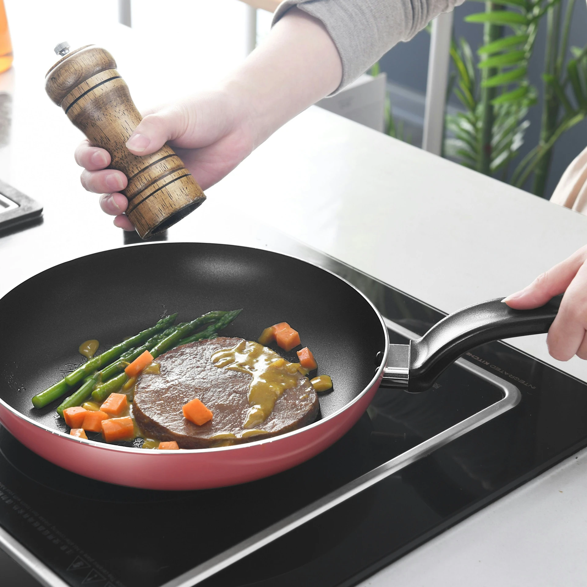 a person pouring seasoning over a set on a stove with vegetables